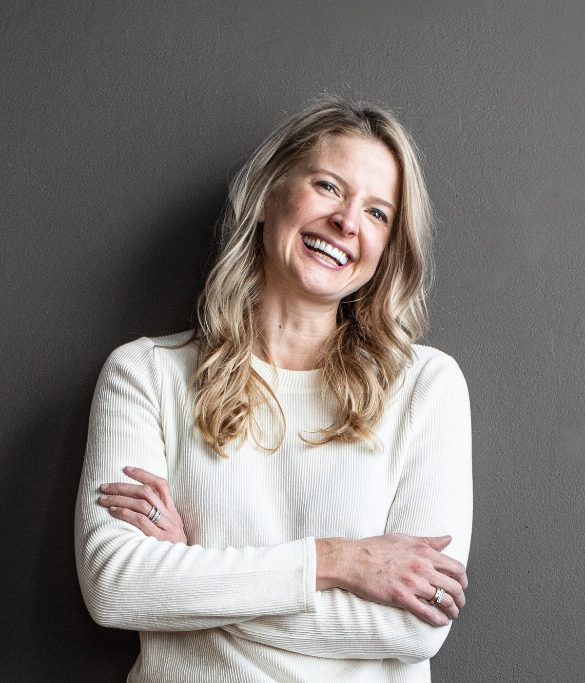Abbie Weeks, founder of Life Happier, smiling with her arms crossed